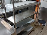 une cuisine équipée d'étagères en inox et d'un plan de travail en métal