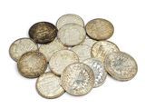 a pile of old coins on a white surface