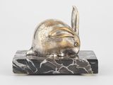 sculpture représentant un lapin assis sur un bloc de marbre, sur fond blanc