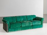 green velvet sofa in a white room with a white wall