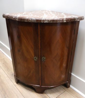 une armoire en bois avec un plateau en marbre posée sur un parquet en bois massif