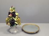un petit sapin de Noël orné de grappes de raisin, à côté d'un miroir