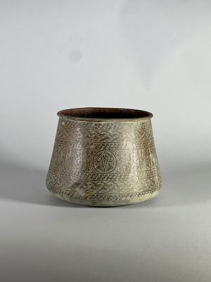 une photo d'un vase argenté posé sur une table blanche