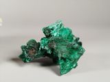 two pieces of green metal sitting next to each other on a white surface