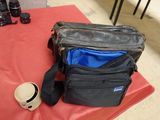 a camera bag and a hat sitting on a table