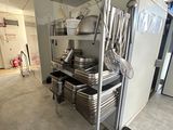several pans and pans are stacked on a cart in a kitchen