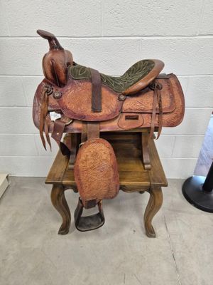 une selle de cheval posée sur un banc en bois