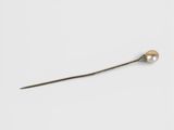 a close up of a metal stick with a pearl on it