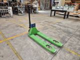 a green forklift sitting in the middle of a warehouse floor