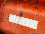 a rusted red motorcycle with a white sticker on it