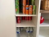 a cabinet that has a lot of sodas and drinks on it