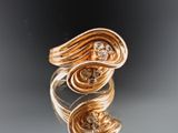 an image of a gold and diamond ring on a reflective surface