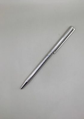 a silver pen sitting on top of a white table next to a black pen