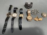 many different types of watches and bracelets laid out on a table