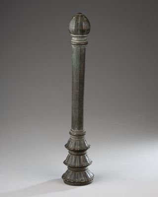 an old metal pole with a metal ball on top of it