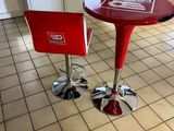 a red table and two red chairs in a kitchen