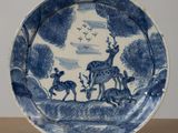 a blue and white plate with a picture of animals on it