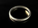 gros plan d'une bague en argent sur une surface noire