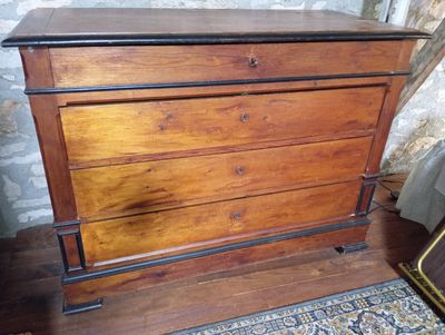 une commode en bois posée sur un parquet