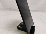 a small black tablet on a stand on a white surface