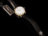 a close up of a watch on a black background with a tag
