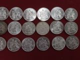 a close up of a bunch of silver coins on a red surface