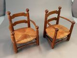 pair of wooden chairs with cane back and seat cushions