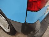 a close up of a blue and white car with a red tail light