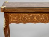 a wooden table with a marble top and gold decoration
