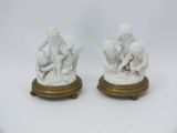 pair of white marble figurines of a boy and a girl on a pedestal