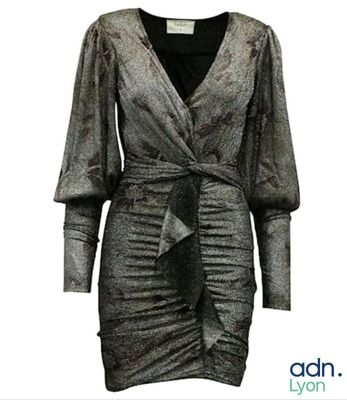 the woman is wearing a silver dress with a black top