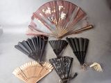 many different types of hand fans on the table