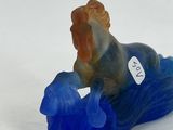a small figurine of a dog sitting on top of a blue object