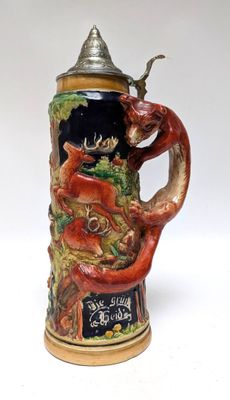 une chope de bière ornée d'un dragon, posée sur une table