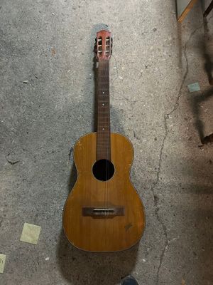 une guitare posée par terre dans la pièce
