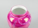 a pink vase sitting on a table with a white background