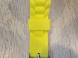 yellow plastic watch on a wooden table with a white face