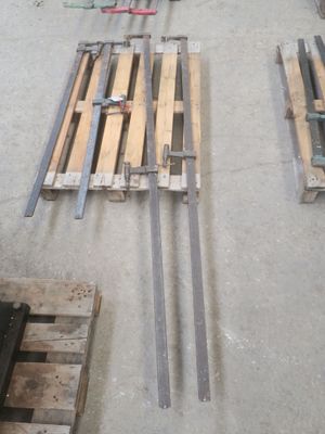 Plusieurs palettes de bois sont posées à même le sol dans un entrepôt