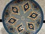 blue and brown decorative plate with a flower design on it