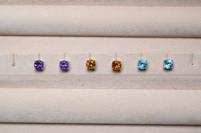 cinq pierres précieuses de couleurs différentes sont disposées en ligne sur une surface blanche