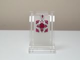 ruby and diamond earrings on display in clear acrylic holder