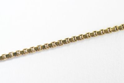 a close up of a gold chain on a white surface