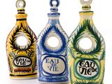 trois bouteilles en céramique de couleurs et de motifs différents posées sur une surface blanche