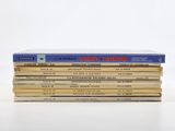 several books stacked on top of each other on a white surface