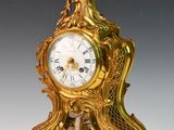 une horloge en or posée sur une table blanche
