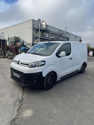 la camionnette blanche est garée devant un bâtiment