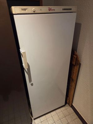 un réfrigérateur blanc dans le coin d'une pièce