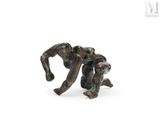 statue of two men wrestling each other on a white surface