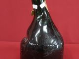 a black bottle that is sitting on a red surface