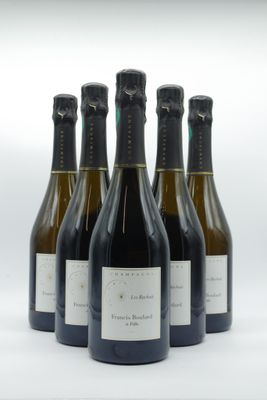 six bouteilles de vin sont alignées sur une surface blanche